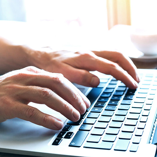 hands typing in a laptop
